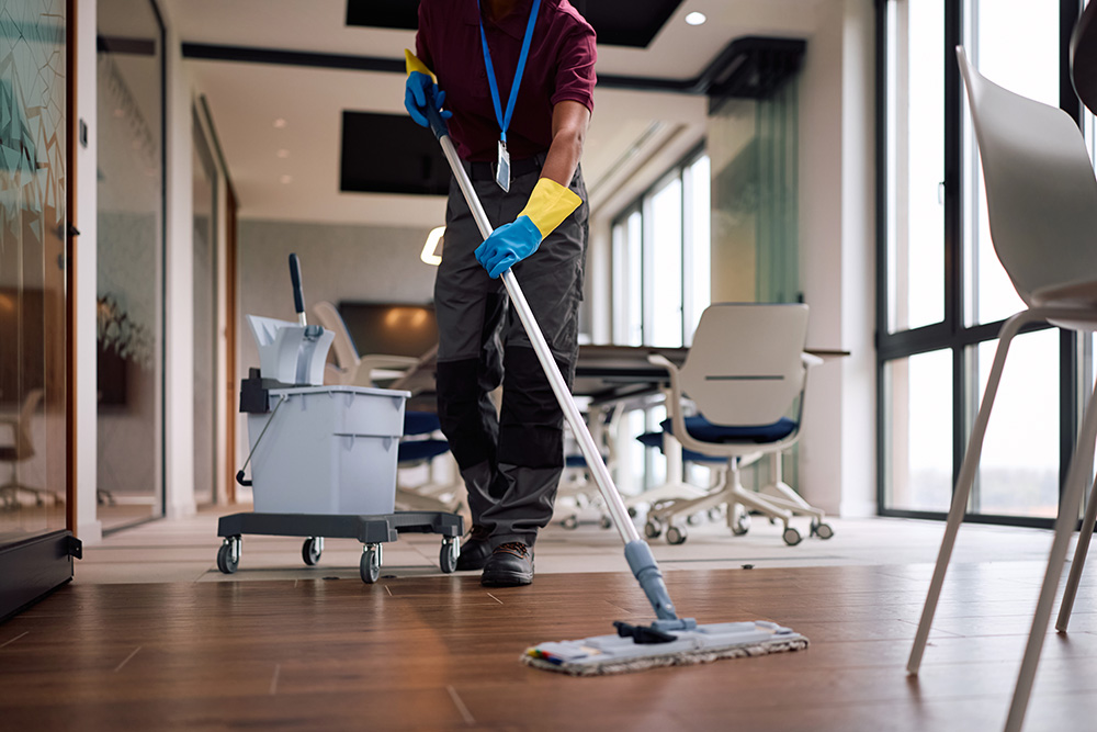 Commercial cleaner mopping wooden office floors for MMM Cleaning and Facility Services in Ann Arbor.